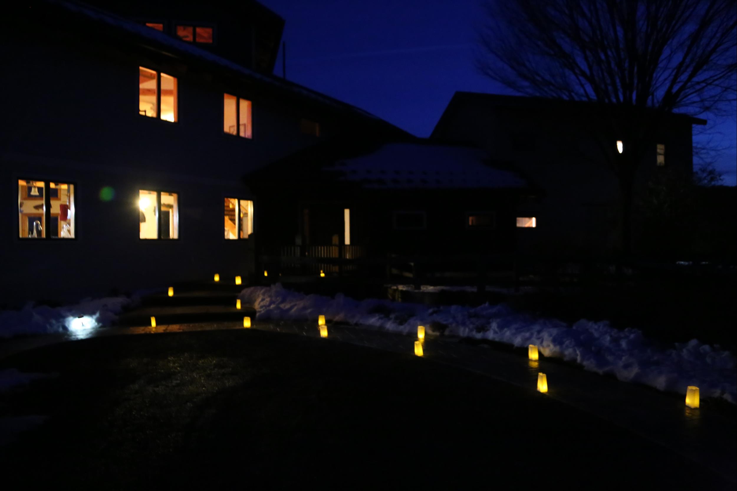 luminaries approaching house at dusk